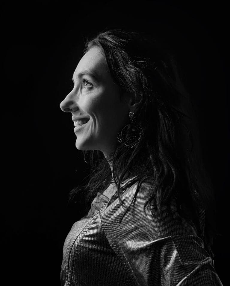 A self-portrait of Eline Kouijzer, 3D artist and founder of E-Line Vision, captured in a dramatic, Rembrandt-inspired lighting style. The image showcases Eline’s mastery in playing with light and shadow, reflecting her expertise in 3D visualizations and photorealistic renderings for architecture and interior design. Her work, executed with tools like 3ds Max and V-Ray, translates her deep understanding of texture and mood into tailored designs for residential and commercial projects. Eline’s portrait symbolizes her ability to bring depth and emotion to both digital and physical spaces, serving clients across Tubbergen, Twente, and beyond