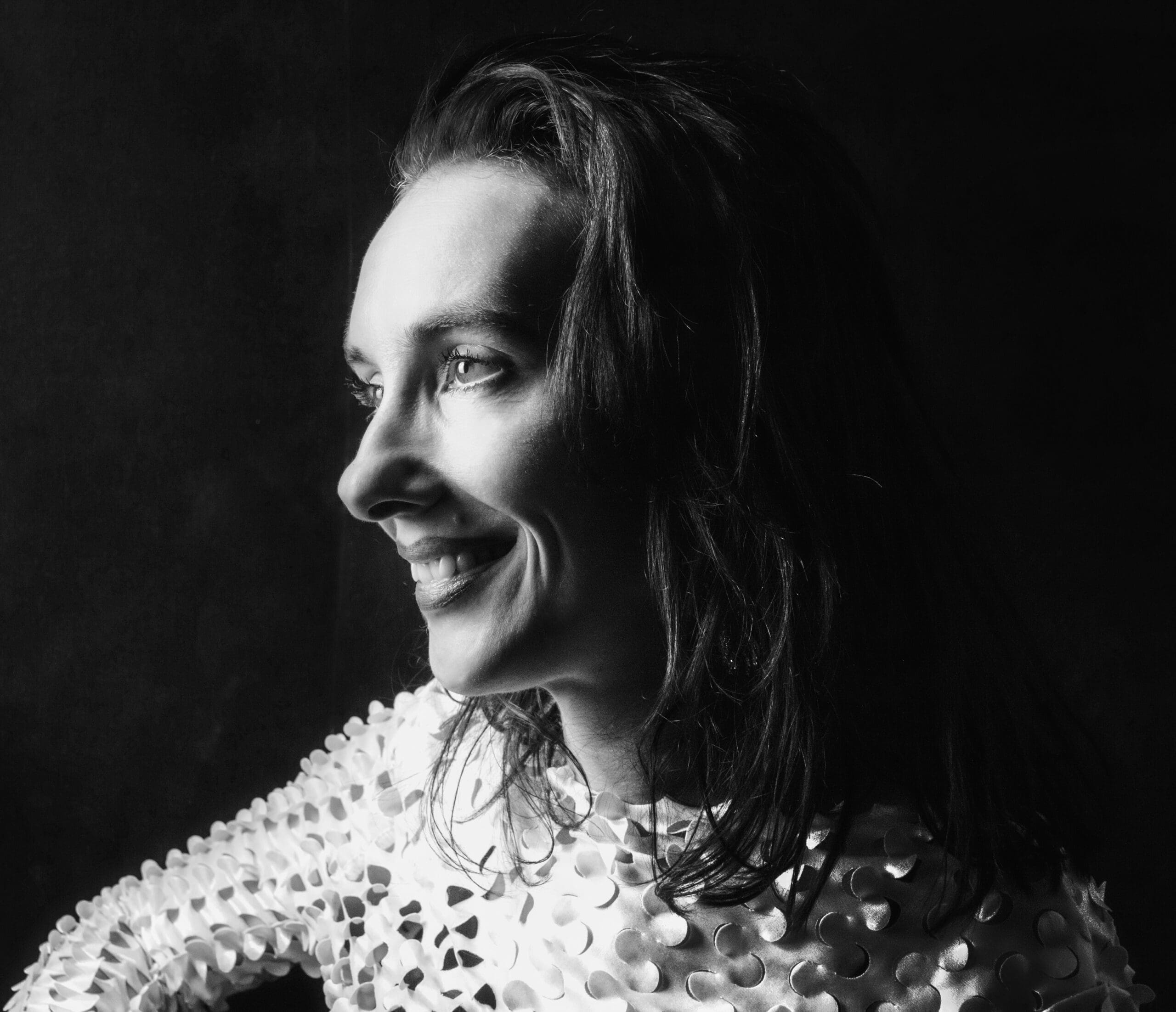 A self-portrait of Eline Kouijzer, 3D artist and founder of E-Line Vision, captured in a dramatic, Rembrandt-inspired lighting style. The image showcases Eline’s mastery in playing with light and shadow, reflecting her expertise in 3D visualizations and photorealistic renderings for architecture and interior design. Her work, executed with tools like 3ds Max and V-Ray, translates her deep understanding of texture and mood into tailored designs for residential and commercial projects. Eline’s portrait symbolizes her ability to bring depth and emotion to both digital and physical spaces, serving clients across Tubbergen, Twente, and beyond